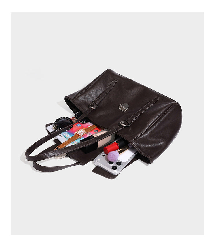 Large structured vintage-style tote bag with flap-front turn-lock closure, twin buckle straps, and double shoulder handles