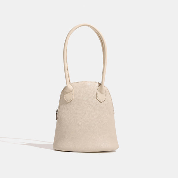 Rounded shell handbag with pebbled leather-look finish, dual top handles, and silver-tone zipper, detail view 7