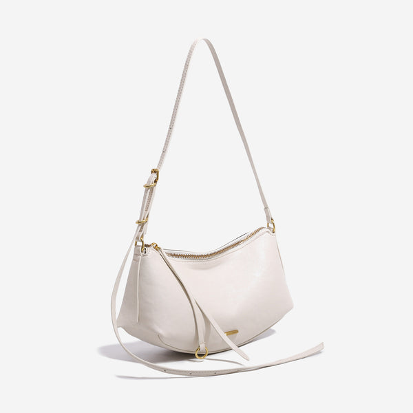 Compact soft rounded zip-top shoulder bag with gold-tone hardware and adjustable crossbody strap, detail view 3