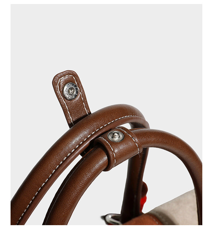 Structured color-block satchel bag in brown, rust, beige, and taupe suede-look panels with white topstitching, front buckle
