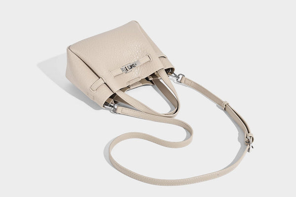 Small structured pebbled bucket tote with double top handles, silver turn-lock hardware, and detachable shoulder strap