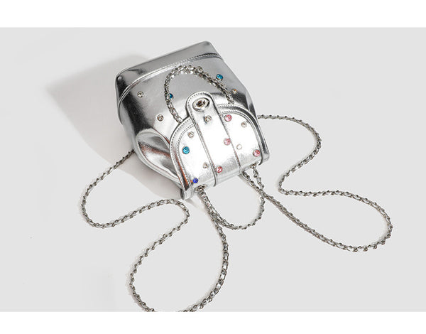 Kompakter Rucksack in Silbermetallic mit mehrfarbigen Kristallnieten, runder Klappe mit Drehverschluss und ineinander verflochtenem Silber