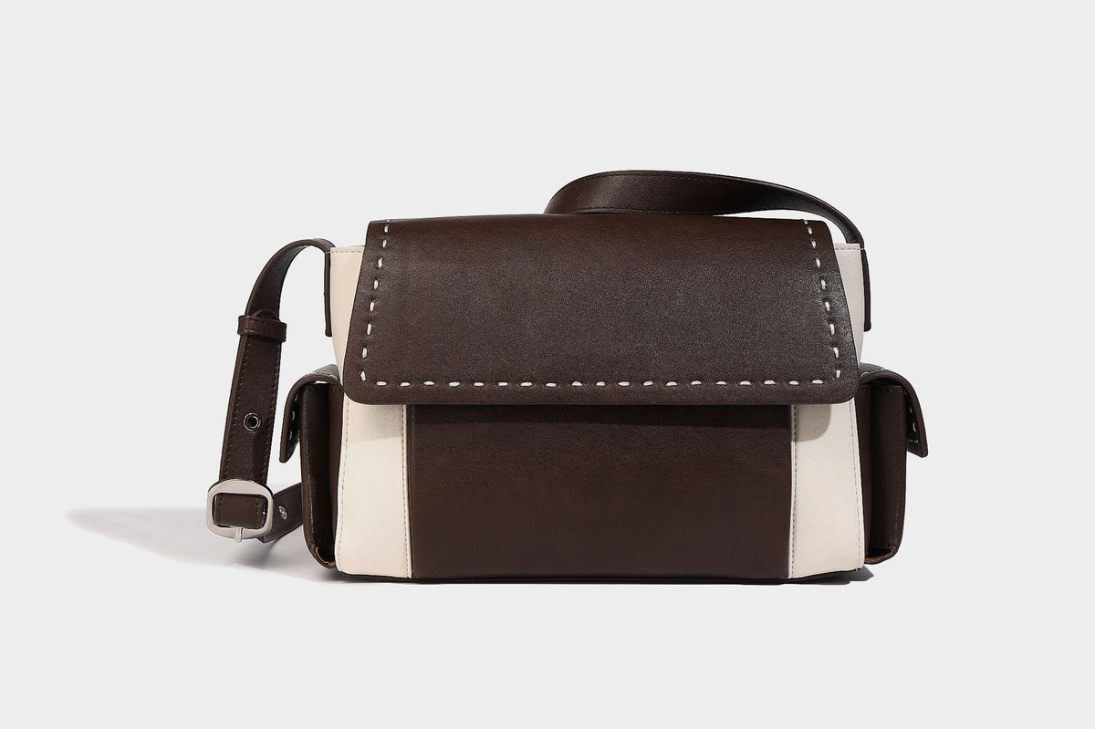 Structured flap crossbody bag in dark brown and cream color-block with white contrast stitching, adjustable shoulder strap