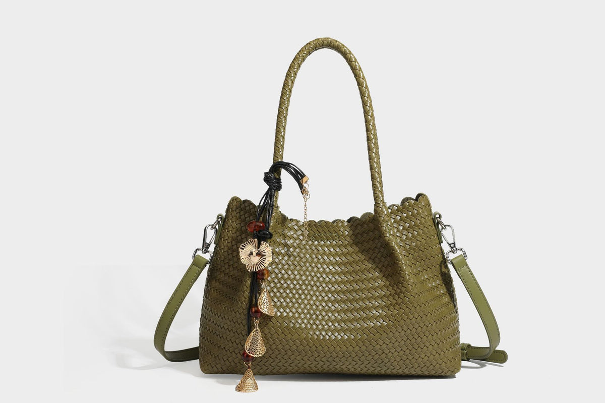 Strukturierter, glänzend geflochtener Shopper mit Muschelkantenabschluss am oberen Rand, geflochtenen Tragegriffen, abnehmbarem Crossbody-Riemen und Perlenquaste