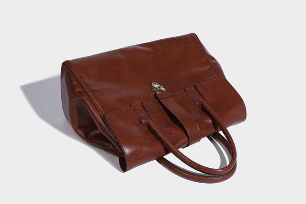 Strukturierte Henkeltasche in glänzender Lederoptik mit Überschlagverschluss, mittigem Riemen, goldfarbenem Drehverschluss und zwei Henkeln