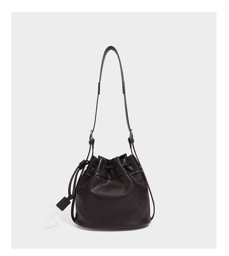 Kleine dunkelbraune Beuteltasche mit Kordelzug, langem verstellbarem Crossbody-Riemen und silberfarbenen Beschlägen, Detailansicht 16