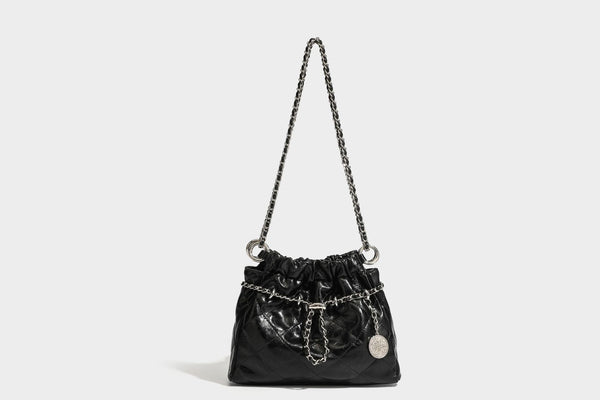 Glossy diamond-quilted drawstring bucket bag with silver chain shoulder strap and medallion charm, detail view 25