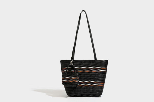 Large structured woven tote bag with striped basket-weave finish, long shoulder straps, and detachable mini pouch charm