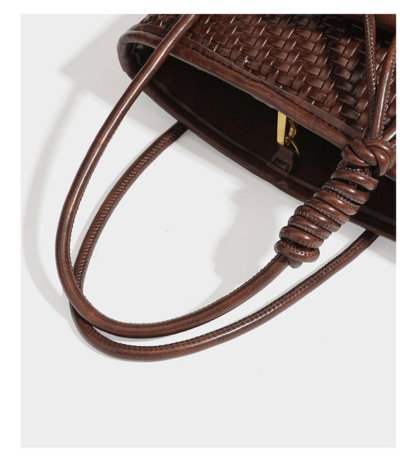Structured woven-texture leather-look bucket bag in brown with knotted top handles, small front flap pouch, and adjustable
