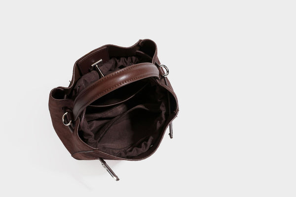 Small structured bucket satchel in embossed velvet-texture fabric with silver turn-lock hardware, rounded top handle, and