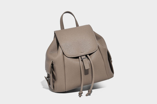Compact pebbled leather-look flap drawstring backpack handbag with side pockets, top handle, and silver-tone hardware, detail