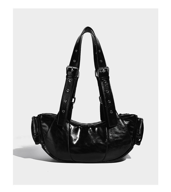 Glossy black crescent shoulder bag with silver-tone rivets, multiple zip pockets, and long adjustable studded straps, detail