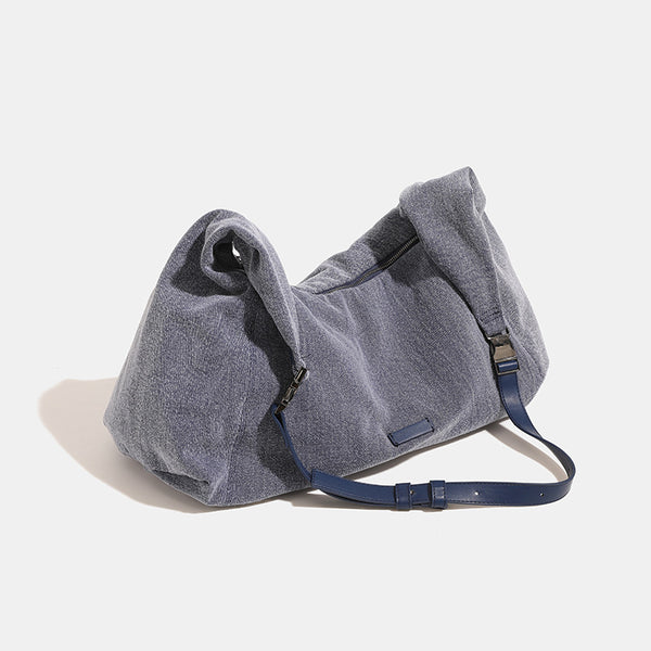 Oversized slouchy black textured canvas hobo shoulder bag with zip-top closure and adjustable dark-hardware strap, detail