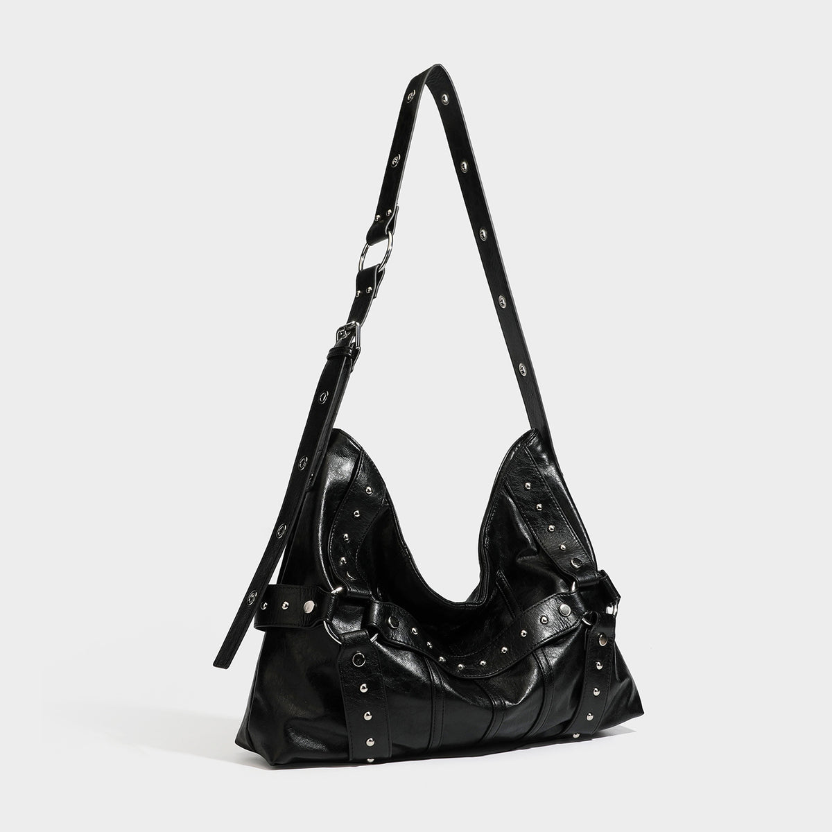 Slouchy hobo shoulder bag in glossy leather-look finish with silver-tone rivets, buckle strap detail, and zip-top closure