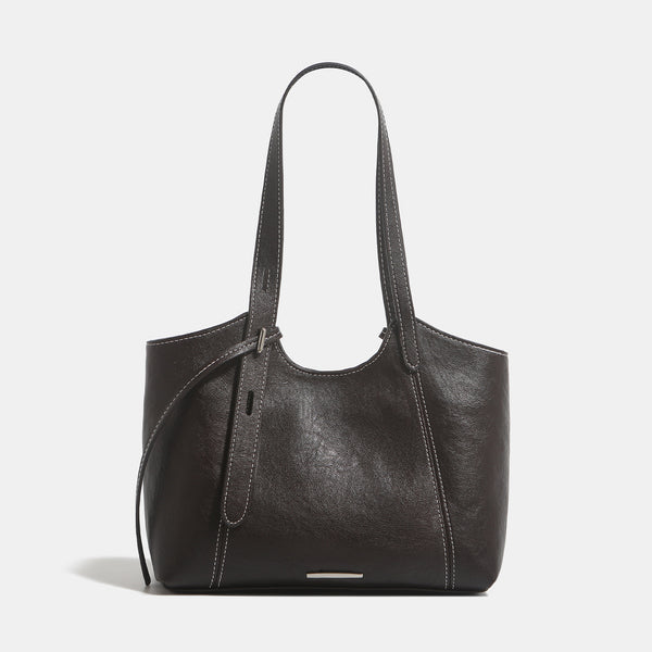 Structured leather-look tote shoulder bag with double crossed straps, contrast topstitching, and metal bar hardware, detail
