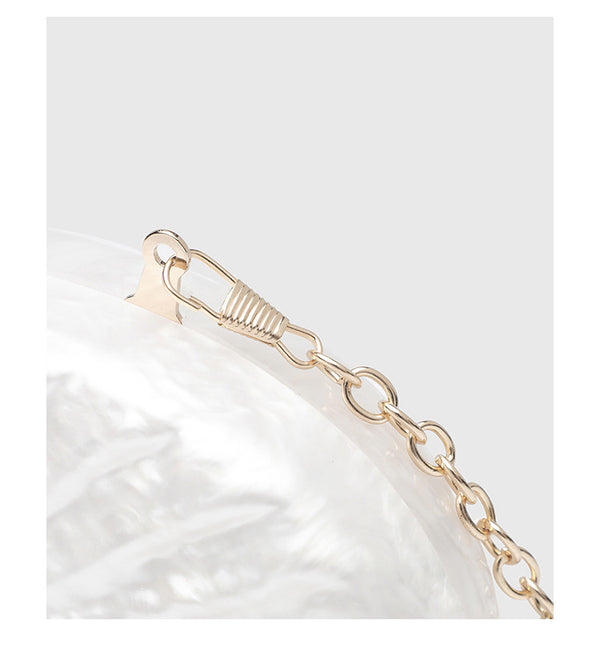 Oval pearl-finish shell clutch bag with gold-tone clasp and removable gold link chain strap, detail view 11