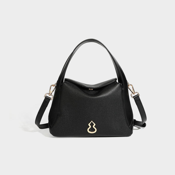 Structured pebbled leather-look shoulder bag with flap top, gold-tone emblem hardware, dual top handles, and detachable
