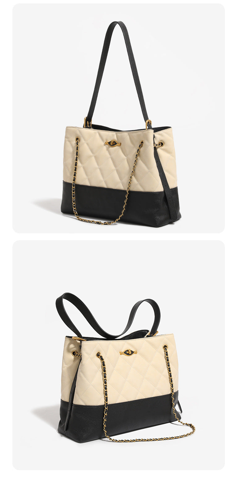 Large quilted two-tone shoulder tote bag with gold-tone chain handles and eye-shaped clasp hardware, detail view 10