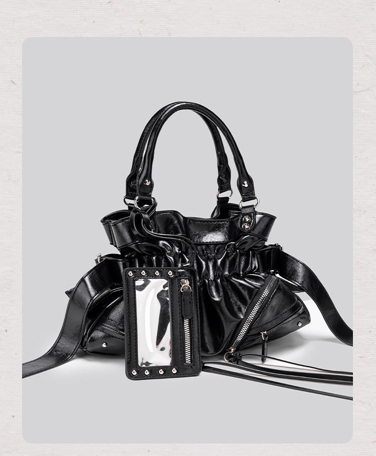 Black glossy ruched convertible tote bag with silver-tone rivets, detachable wide shoulder strap, external zip pouch, and
