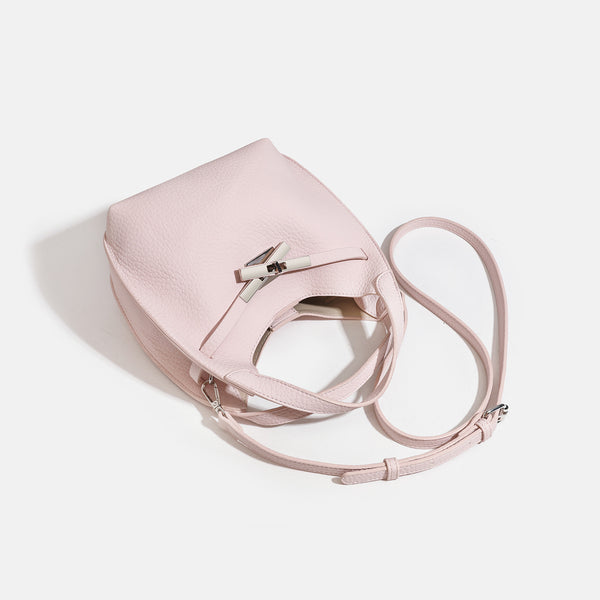 Compact pebbled leather-look shoulder bag with crossed silver-toned metal front closure, short top handle, and long, detail