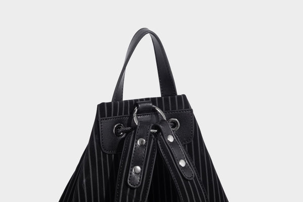 Schwarze wandelbare Rucksack-Handtasche mit Nadelstreifen, Kordelzugverschluss, Tragegriff aus Lederimitat und matten Metallbeschlägen, Detailansicht