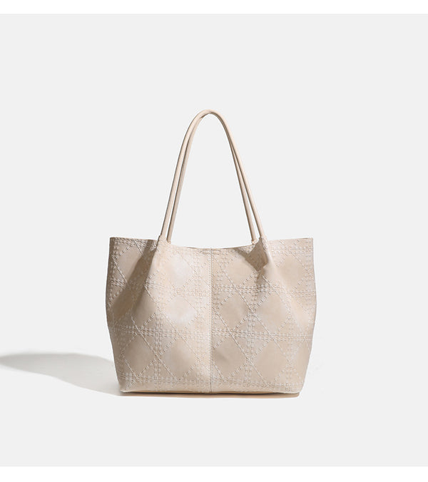 Large open-top tote bag with raised diamond-lattice stitching, long double shoulder handles, and gold-tone magnetic snap
