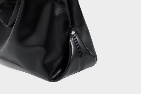 Große schwarze, glänzende Hobo-Schultertasche in Lederoptik mit mit Ösen besetztem Riemen, silberfarbenen Beschlägen und abnehmbarem