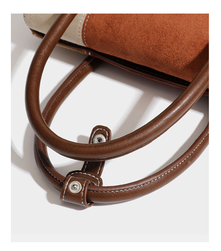 Structured color-block satchel bag in brown, rust, beige, and taupe suede-look panels with white topstitching, front buckle
