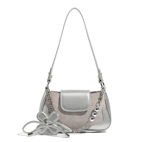 Compact silver flap shoulder bag with pale-pink crocodile-embossed panel, chain bead handle, bow charm, and adjustable