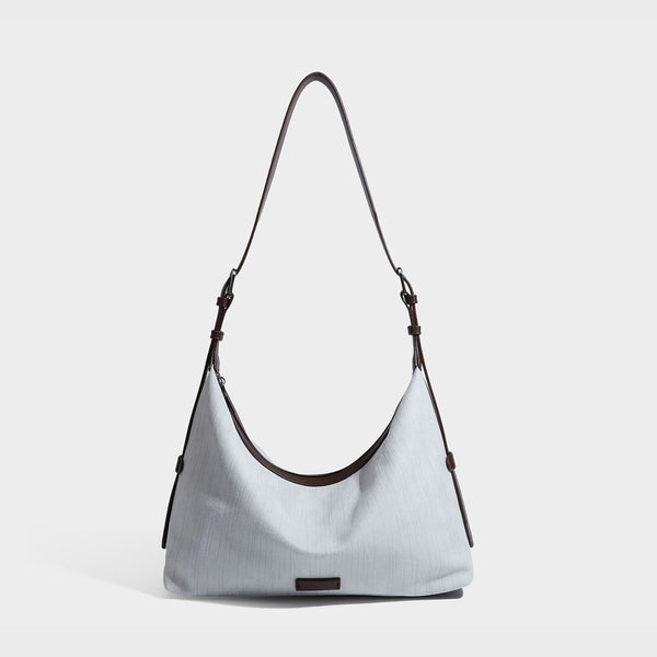 Slouchy olive green canvas hobo shoulder bag with black leather-look trim, zip-top closure, and adjustable strap, detail view