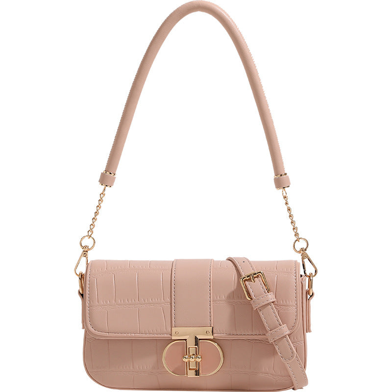 Small structured crocodile-embossed flap shoulder bag with circular gold turn-lock closure and chain-accent strap, detail