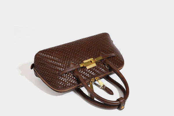 Structured woven-embossed leather-look satchel with dual rolled top handles, gold-tone turn-lock closure, and detachable