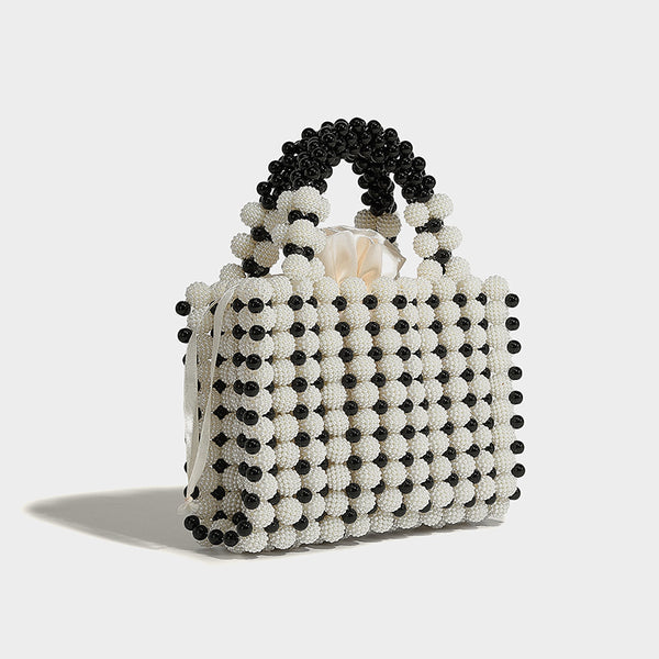 Small boxy pearl-bead mini top-handle bag with silver metallic bead accents, satin floral detail, and long beaded shoulder