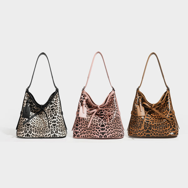 Slouchy leopard print shoulder hobo bag with black leather-look trim, tie-top closure, and single long strap, detail view 2
