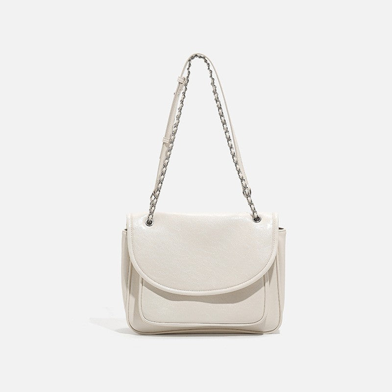 Structured glossy leather-look flap crossbody satchel with woven chain-and-leather shoulder strap, front view
