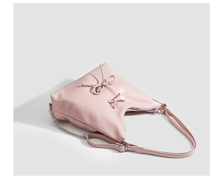 Glossy leather-look hobo shoulder bag with front bow lacing detail and silver-tone chain strap, detail view 16