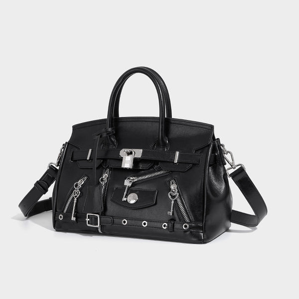 Structured black leather-look satchel bag with silver padlock hardware, front zip pockets, key charms, and top handles, front