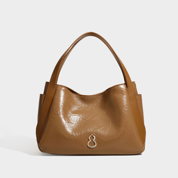 Black glossy crinkled leather-look convertible shoulder tote bag with gold gourd-shaped emblem hardware and detachable