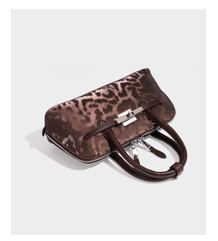 Strukturierte Henkeltasche mit tonal abgestimmtem Leopardenprint, Besatz in Lederoptik, gerollten Henkeln, vorderem Drehverschluss und