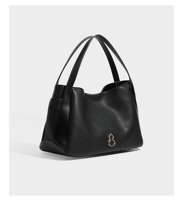 Schwarze Tote-Bag aus genarbtem Material in Lederoptik mit kürbisförmigen Beschlägen in Goldoptik, zwei Henkeln und abnehmbarem Umhängeriemen, Detailansicht