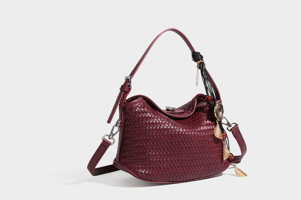 Small woven-look leather-look flap shoulder hobo bag in burgundy with silver-tone hardware and decorative tassel charm