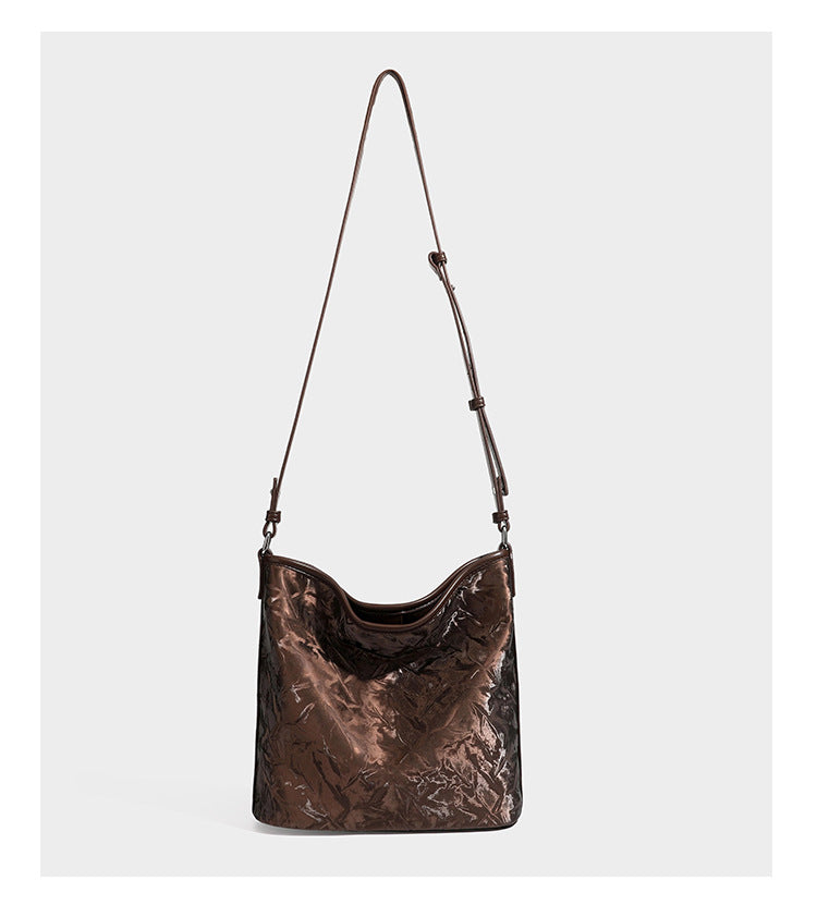 Große Hobo-Schultertasche mit Knitterglanz in Dunkelbraun, schmalem verstellbarem Riemen, geknoteten Metalldetails und seitlich angesetzter Klappe