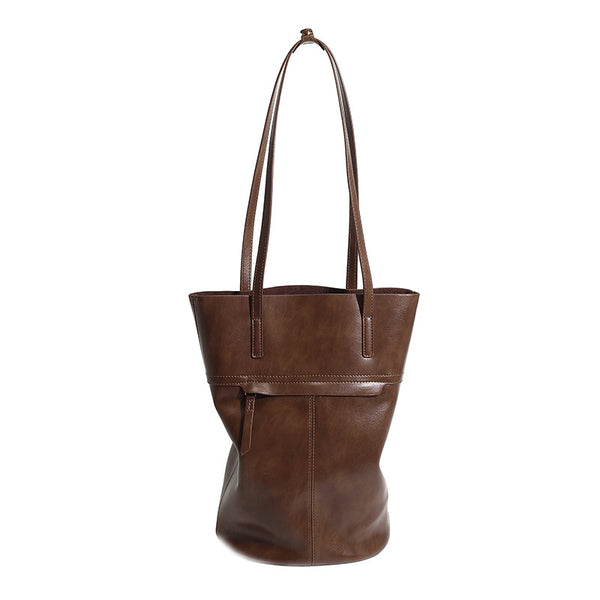 Large black smooth leather-look bucket tote bag with long shoulder straps and open top, detail view 5