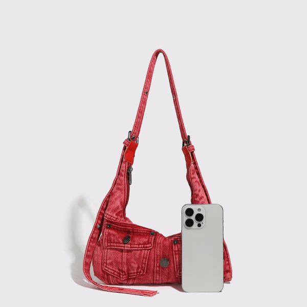 Compact washed red distressed-textile shoulder bag with front flap pockets, dark metal hardware, and long adjustable strap