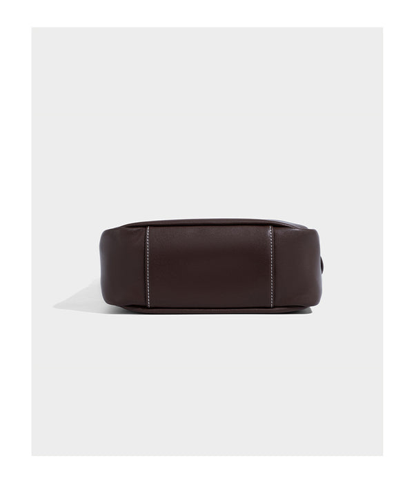 Structured dark brown leather-look bucket bag with white contrast stitching, front wraparound belt buckle strap, and long