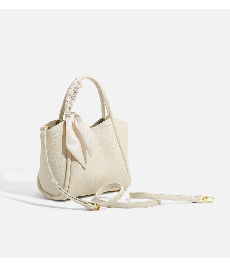Pebbled leather-look bucket tote bag with scarf-wrapped top handle and gold-tone hardware, detail view 17