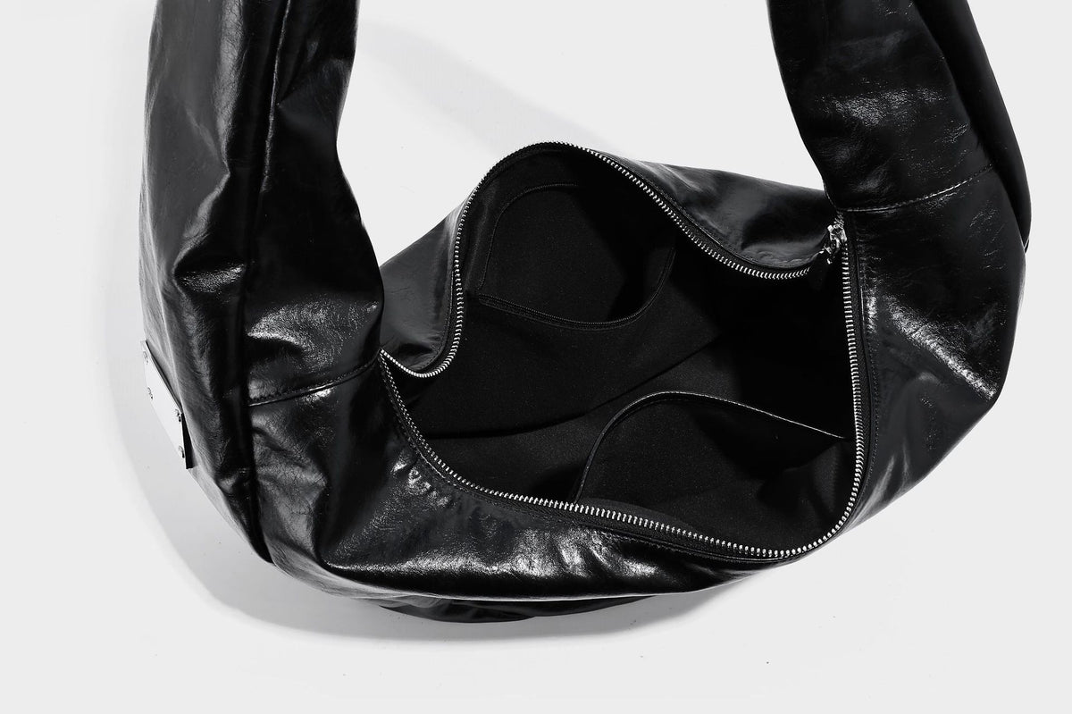 Schwarze, glänzende, weich fallende, halbmondförmige Hobo-Bag mit breitem integriertem Schulterriemen und silberfarbenem Reißverschluss, Detailansicht 23