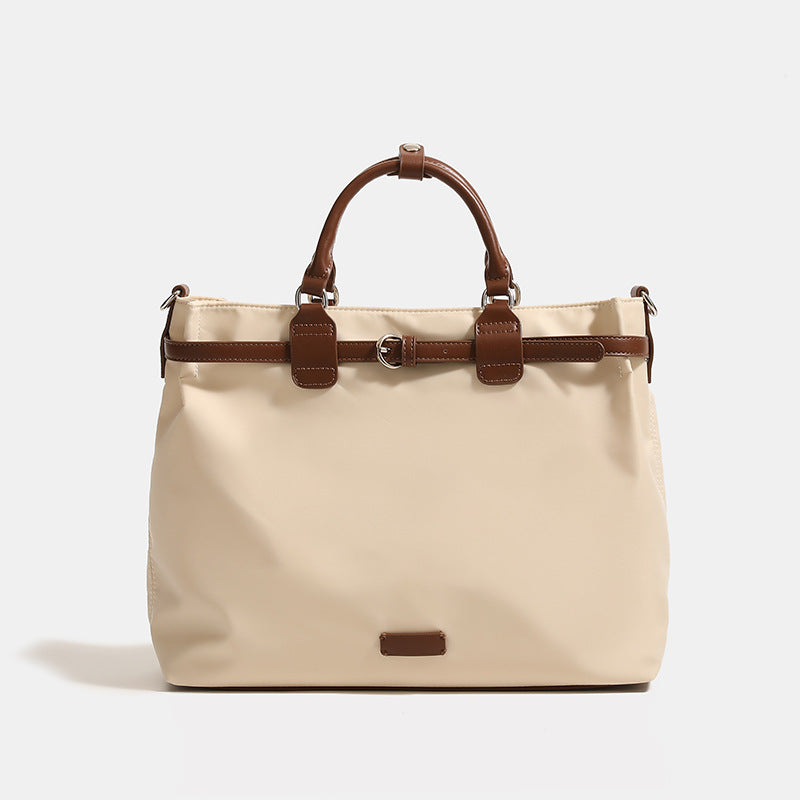 Structured matte tote bag with leather-look brown trim, dual top handles, zip closure, and detachable shoulder strap, front