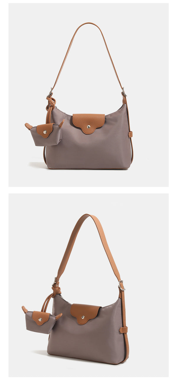 Slouchy hobo shoulder bag in smooth fabric with leather-look tan trim, zip-top closure, adjustable strap, and detachable