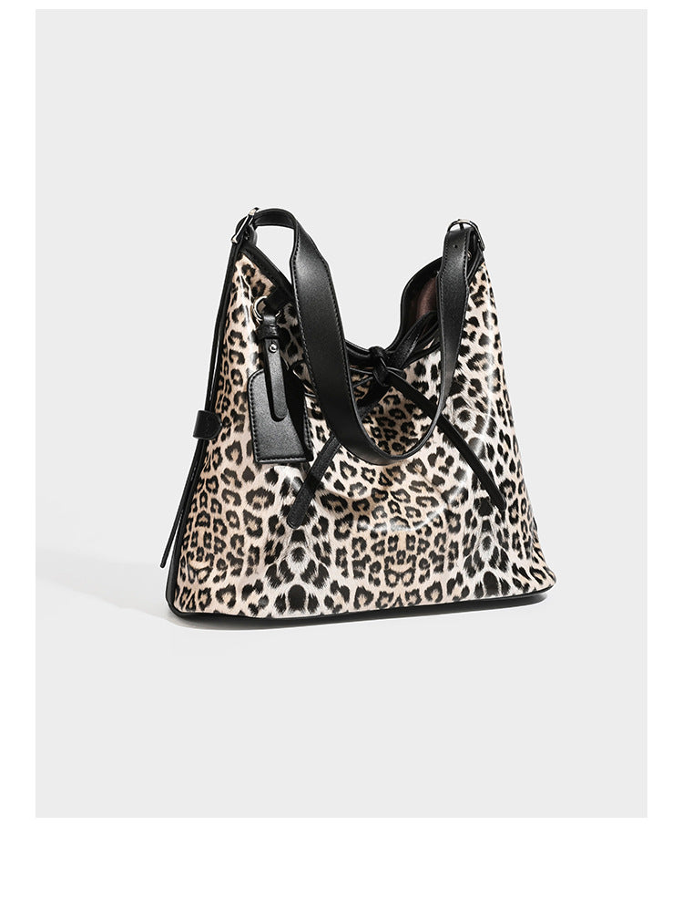 Slouchy leopard print shoulder hobo bag with black leather-look trim, tie-top closure, and single long strap, detail view 7